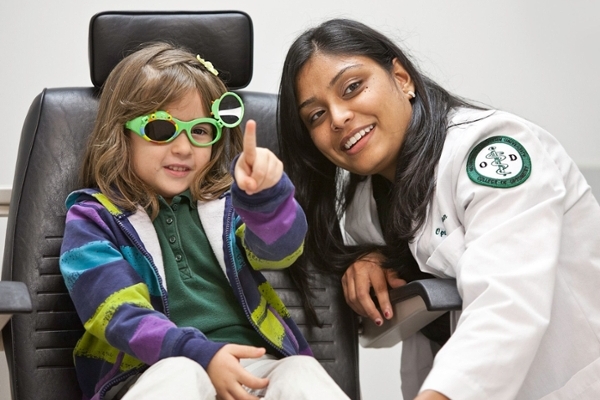 optometry student with child wearing glasses 